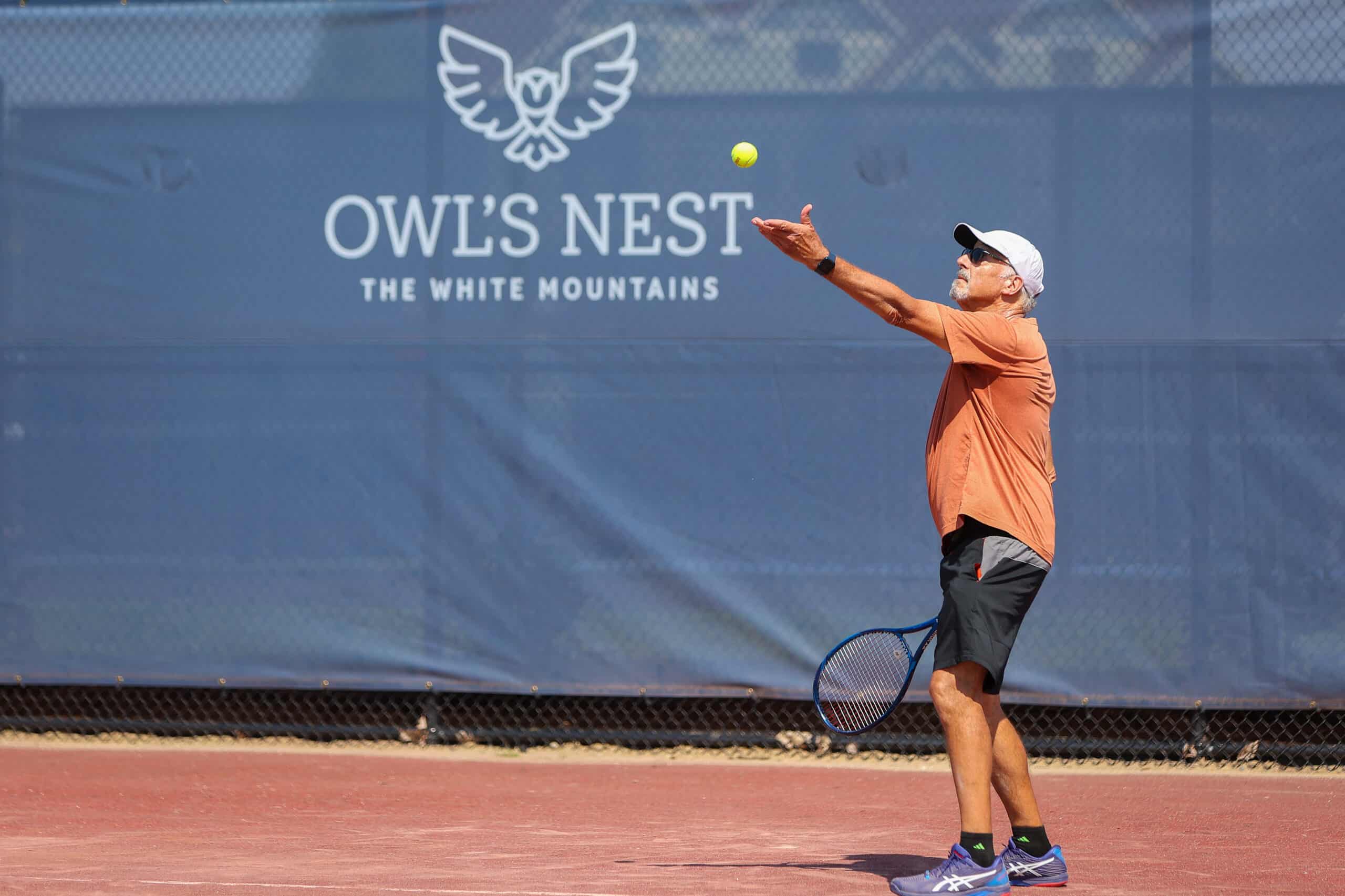 man serving a tennis ball