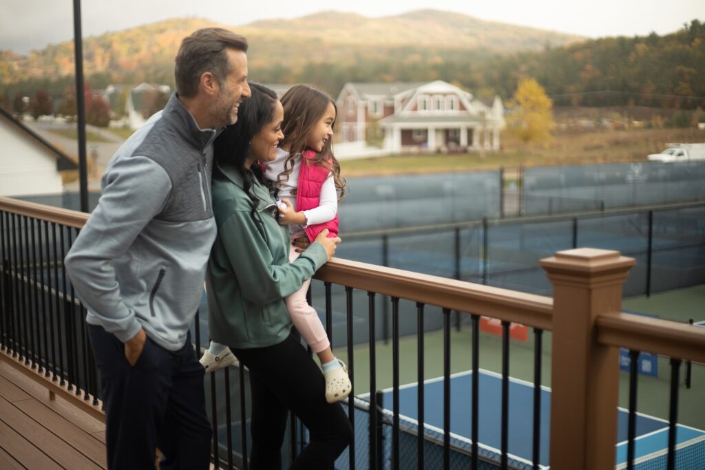 Family enjoying mountain views overlooking tennis courts at a White Mountains resort in New Hampshire