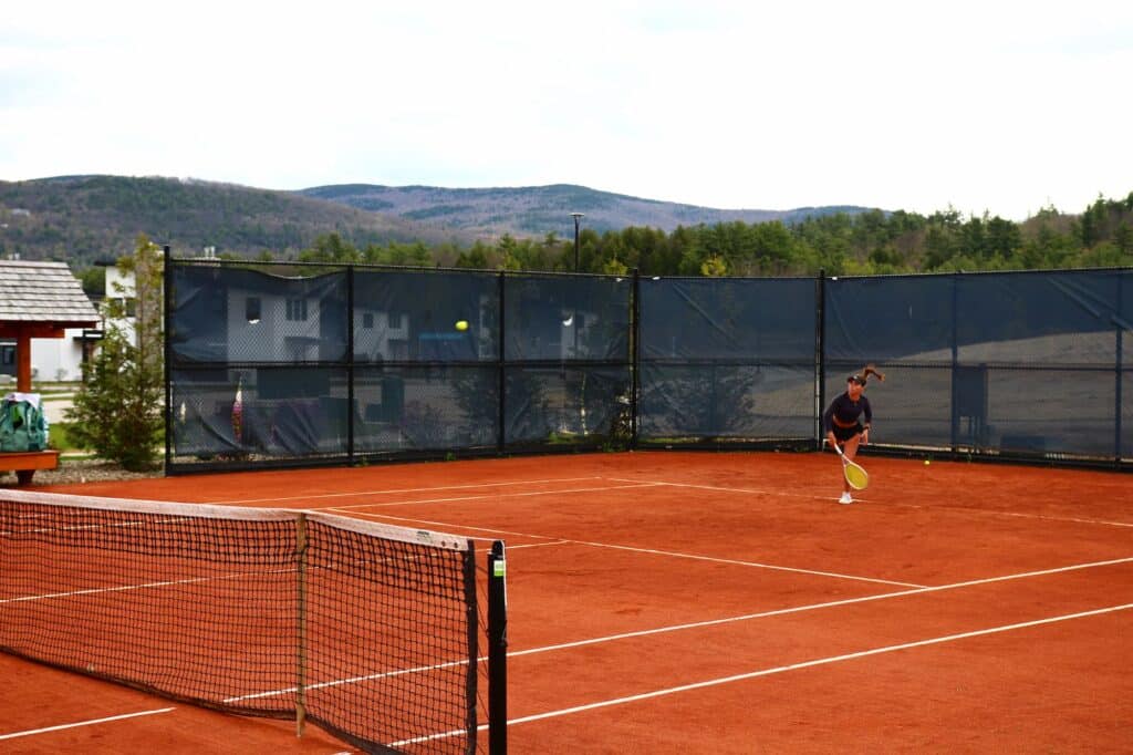 Player competing during the UTR Pro Tennis Tour on the clay tennis courts at Owl’s Nest Resort in New Hampshire.